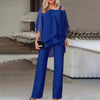 En kvinne modellerer et kongeblått todelt sett med off-shoulder-topp og vide bukser.