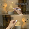 A hand draws a Christmas tree on an illuminated acrylic message board lamp.