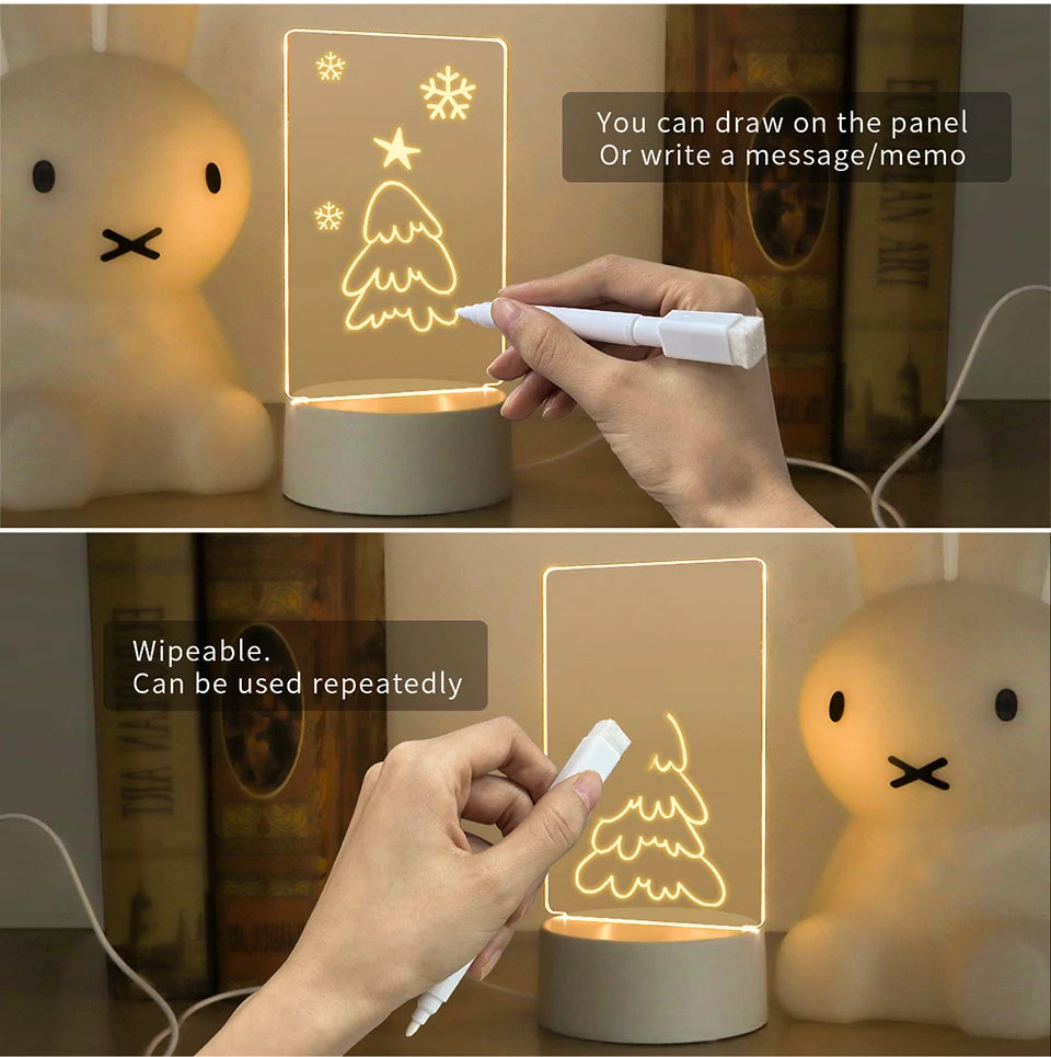 A hand draws a Christmas tree on an illuminated acrylic message board lamp.
