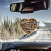 Et hjerteformet ornament med bøker hengende i gullkjede mot et snødekt fjellandskap.
