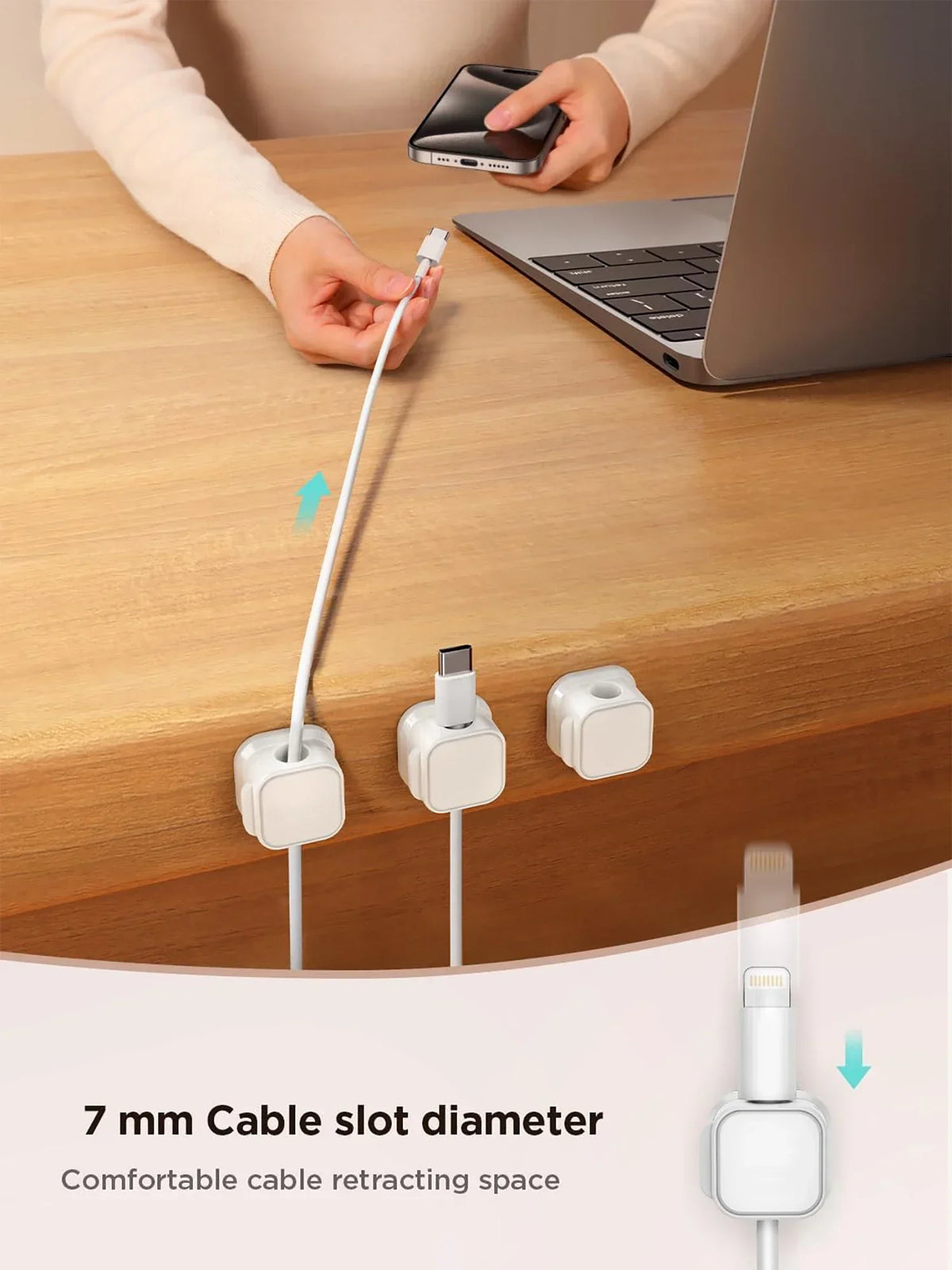 Nærbilde av hvit kabelklips som holder en ladekabel på et trebord.
