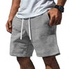 Shorts casual gris de textura waffle para hombre con cordón, usados por una persona.