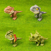 Three plastic dinosaur fossils of different species are displayed on green textured surface.