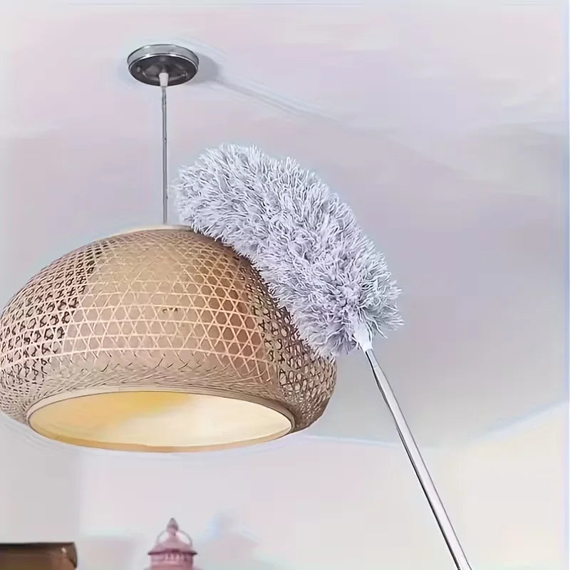 Moderne pendellampe med vevd gyllen skjerm og myk grå mikrofiberstøvkost.