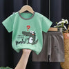 A green dinosaur print kids t-shirt and shorts set displayed on a hanger.