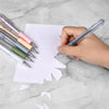 Una mano sostiene seis cuchillas de precisión con repuestos sobre papel blanco.