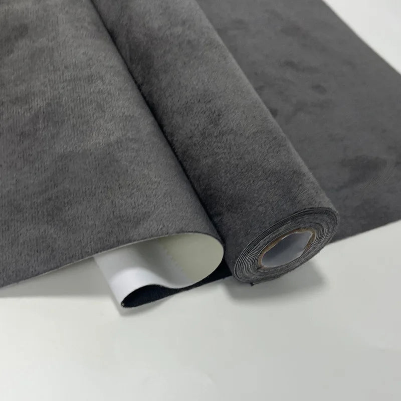 Rollo de tela de gamuza gris con acabado aterciopelado mostrando el borde enrollado.