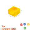 A yellow plastic marble run building block with a funnel shape and tracks.