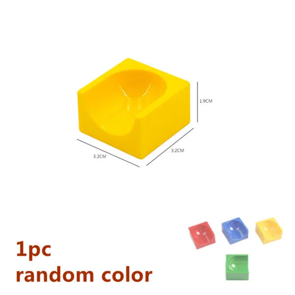 A yellow plastic marble run building block with a funnel shape and tracks.