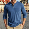 A man wearing a blue long-sleeve casual shirt with a chest pocket, standing outdoors.