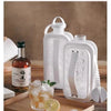 A clear plastic water bottle mold is shown next to a glass of iced drink and a wooden cutting board.