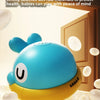 A blue whale-shaped bath toy with a spray feature is shown against a light background.