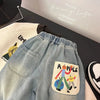 Close-up of light blue denim jeans with an elastic waist and a patch featuring an apple.