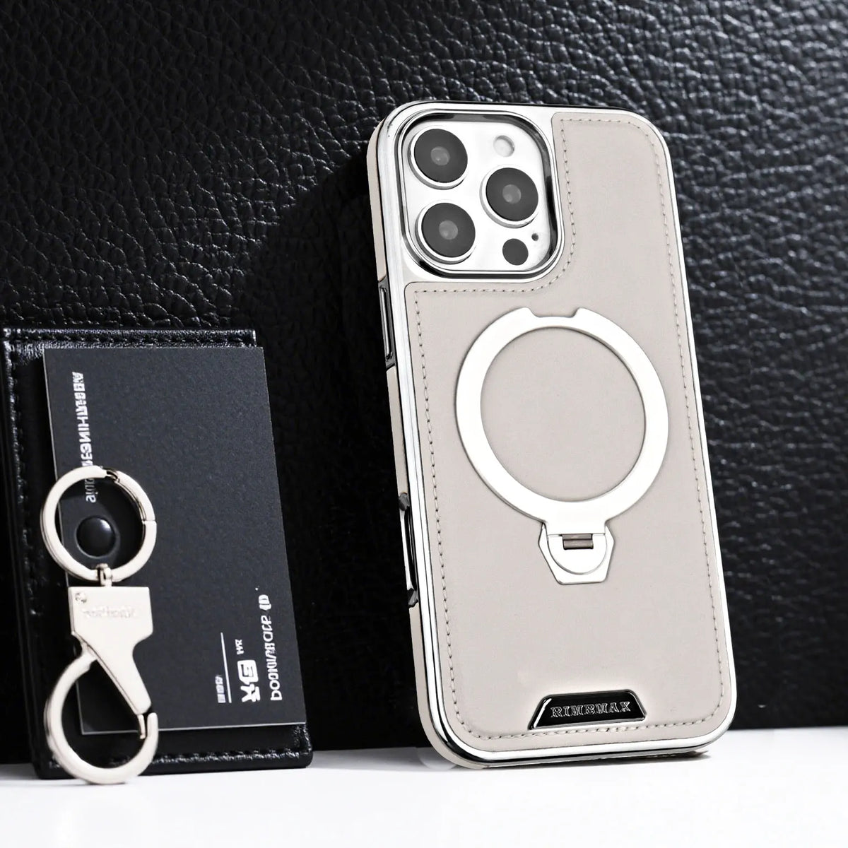 A light beige iPhone case with a rotating magnetic stand feature displayed next to its packaging.