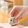 A hand is manually pushing a retractable ceramic blade cutter to retract the blade.