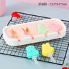 A silicone popsicle mold set featuring pink, green, and yellow fruit shapes on a black wire rack.