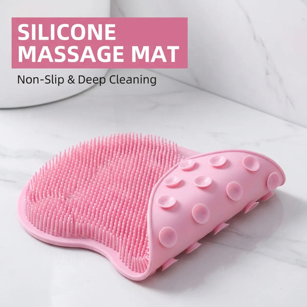 A pink silicone massage mat with textured surfaces is shown on a white marble surface.