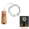 A roll of warm white LED fairy lights with a connector and a light bulb, shown next to its power source.