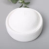 White straw pillbox sun hat with a wide brim shown against a gray background.