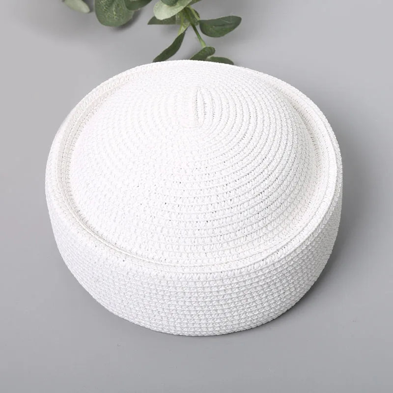White straw pillbox sun hat with a wide brim shown against a gray background.