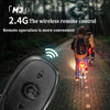 A wireless remote control device is shown next to a bicycle on a paved road with trees in the background.