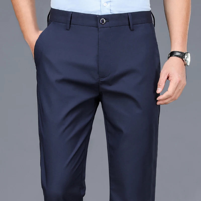 Navy blue men's stretch straight-leg trousers worn by a man, paired with a light blue shirt.