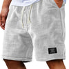 Pantalones cortos informales de waffle gris para hombre con cordón, usados por una persona.