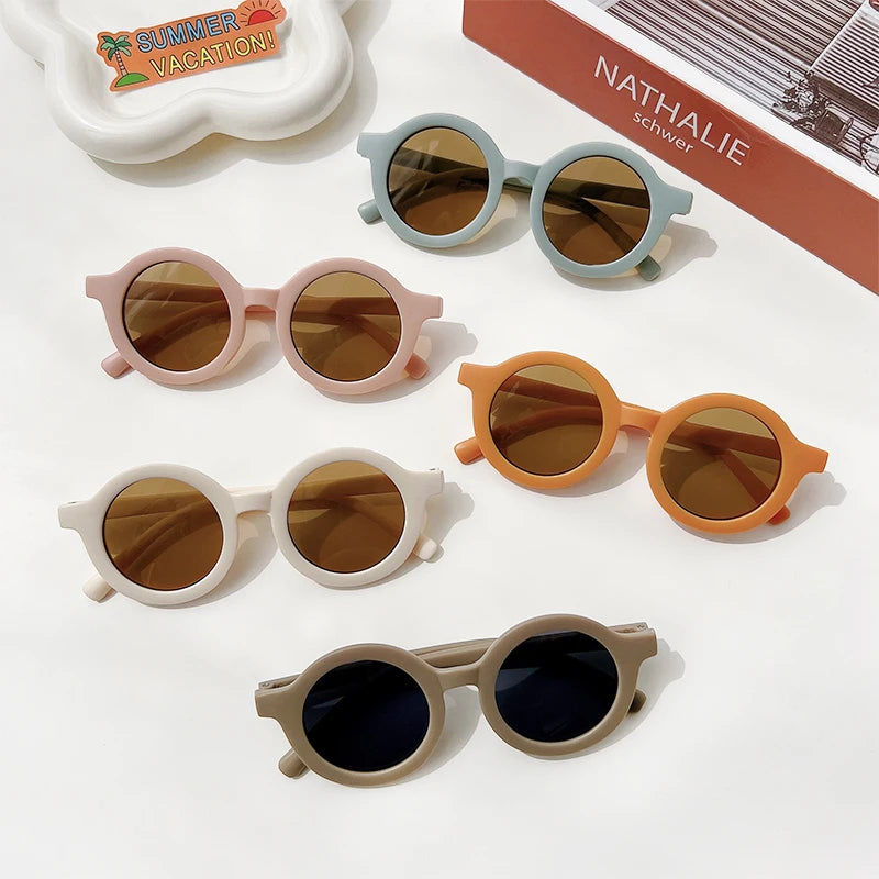 A collection of sunglasses in various colors and styles, including round and oval frames.