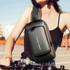 Mujer sosteniendo bolso bandolera antirrobo negro con detalle dorado, ideal para exteriores.