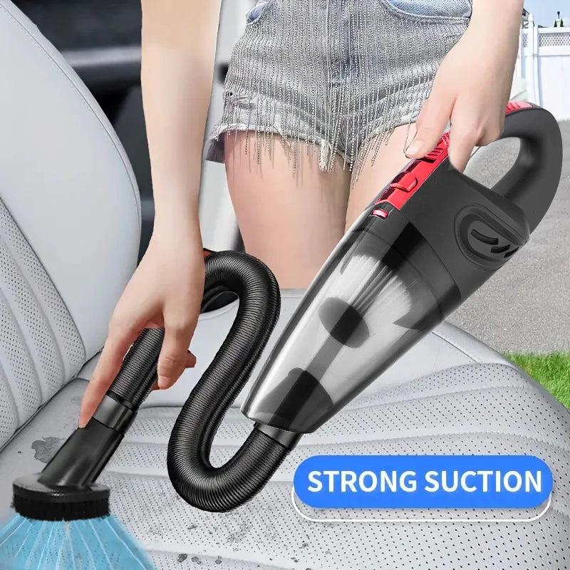 A hand is operating a black cordless handheld vacuum cleaner with a flexible hose and brush on a gray surface.