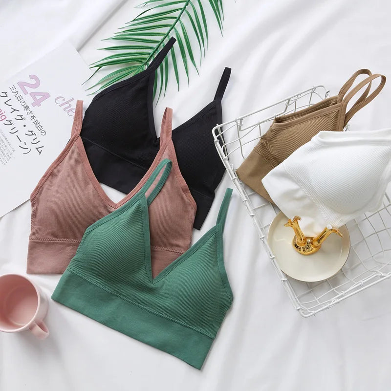 A collection of seamless U-back bralettes in various shades of pink, green, and black are displayed on a white background.