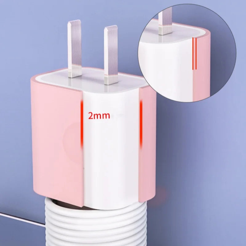 A pink and white silicone charger protector and cable organizer with metal tips, shown next to a coiled white cable.