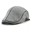 A grey knit wool newsboy cap for men shown from the side.