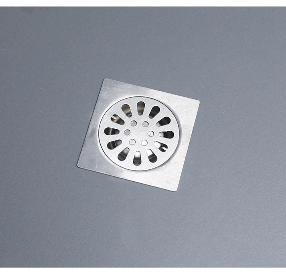 A square metal drain plug with a circular grid of openings for clearing clogs.