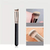 A precision face makeup brush with a black handle and silver ferrule is shown in detail.