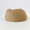 A beige straw pillbox sun hat with a wide brim, shown from the side.