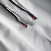 Close-up of black cord with red accents attached to a light gray fabric, showing an adjustable feature on men's cargo joggers