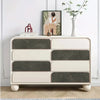 Cómoda blanca de cuatro cajones con tiradores de gamuza gris y detalles de madera clara.