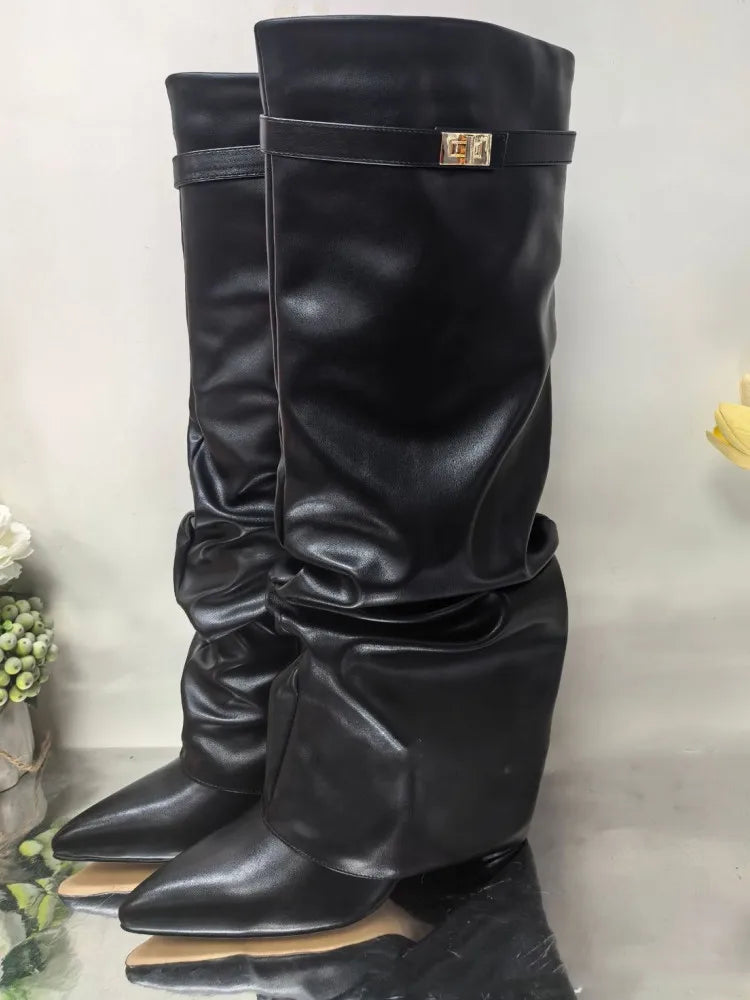 A pair of black knee-high chunky heel boots with a metal buckle displayed against a light background.