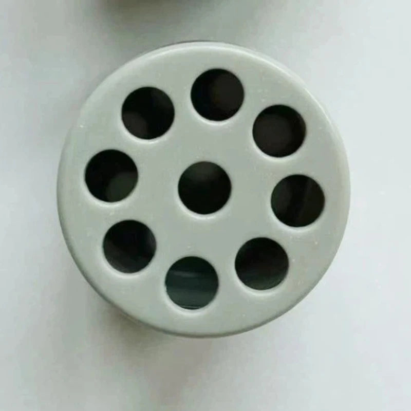 A round, light gray silicone mold with multiple circular depressions for creating spiral flower arrangements.