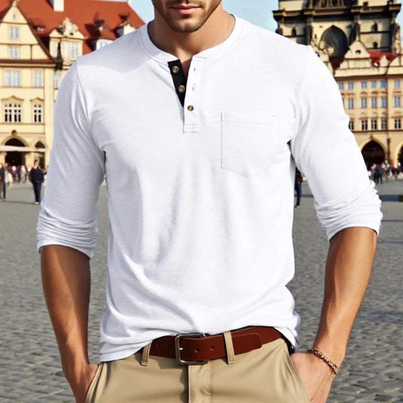 A man wearing a white long-sleeve shirt with a collar and chest pocket, paired with tan pants.