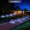 Colorful solar fireworks lawn lights illuminating a backyard landscape at night.