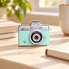 Minimalistisk digital miniatyrkamera på ett solbelyst skrivbord
