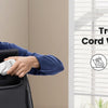 A man holds a black travel extension cord with USB ports in a bright room.